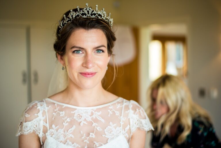 A bride in a veil, holding her bouquet, a wide smile in a garden, Makeup By Becky Flynn