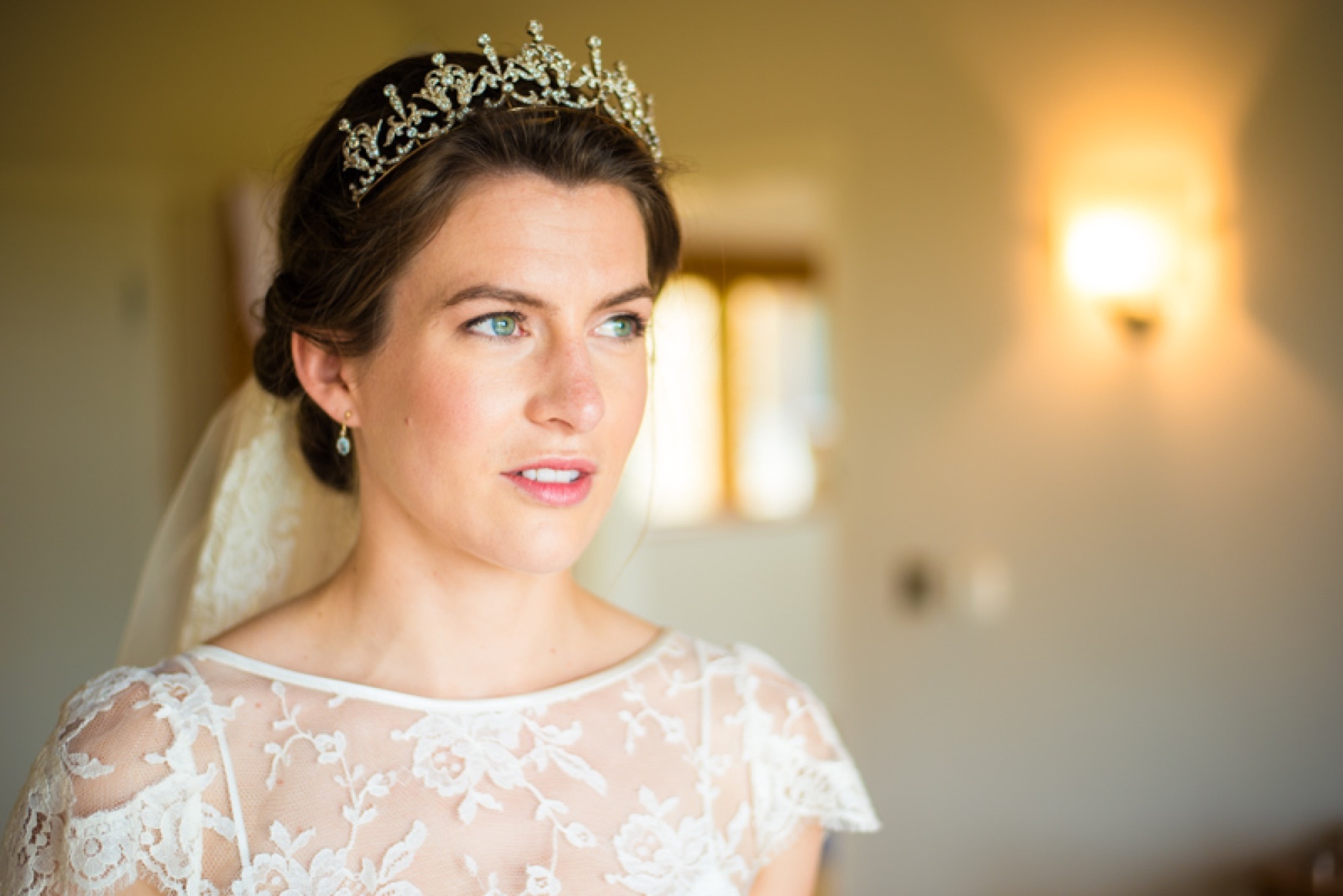 A bride in a long-sleeved lace gown and pearl tiara, a candlelit room, Makeup By Becky Flynn