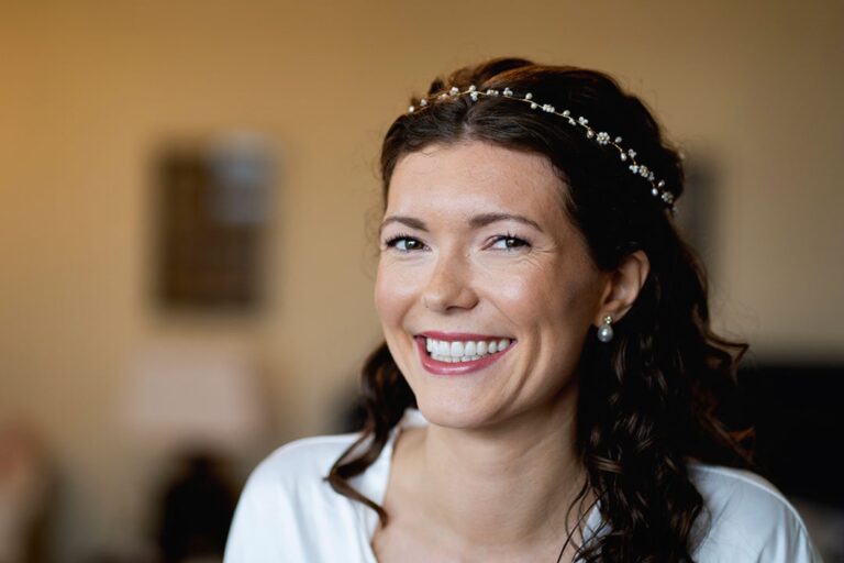 A woman smiling, a pearl headband, a cream top, Makeup By Becky Flynn