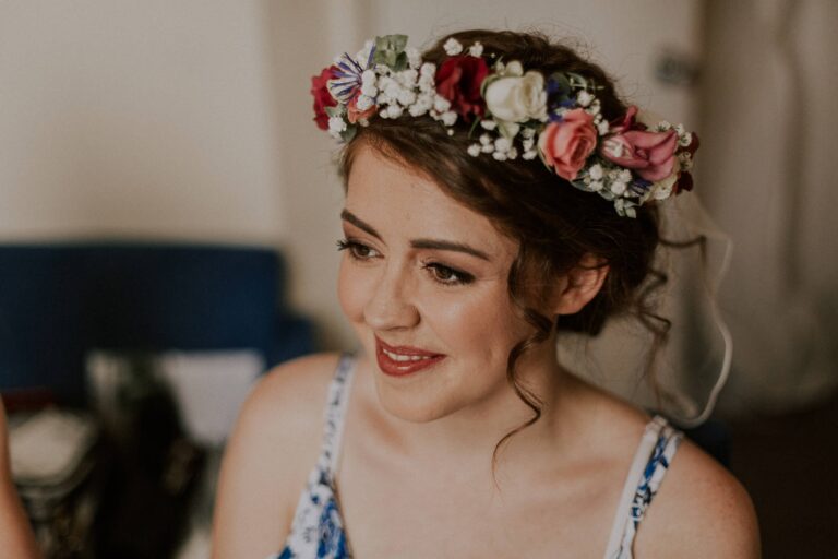 A getting-ready mirror shot, a flower crown and makeup brush in hand, Makeup By Becky Flynn