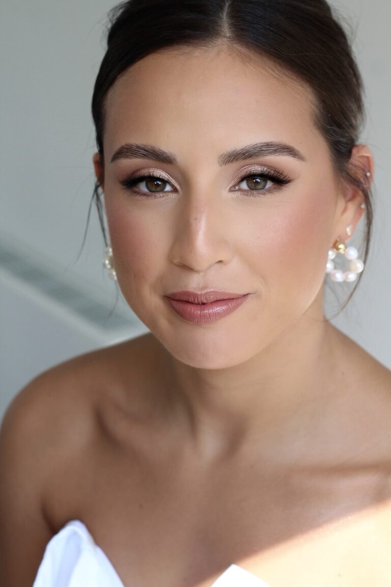 A bride with a pearl drop earring, a low bridal updo, soft glam, Makeup By Becky Flynn