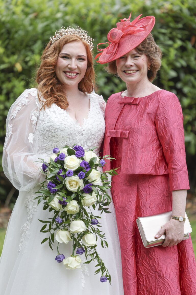 A bride with her mother, cascading bouquet, garden hedge behind, Makeup By Mirna