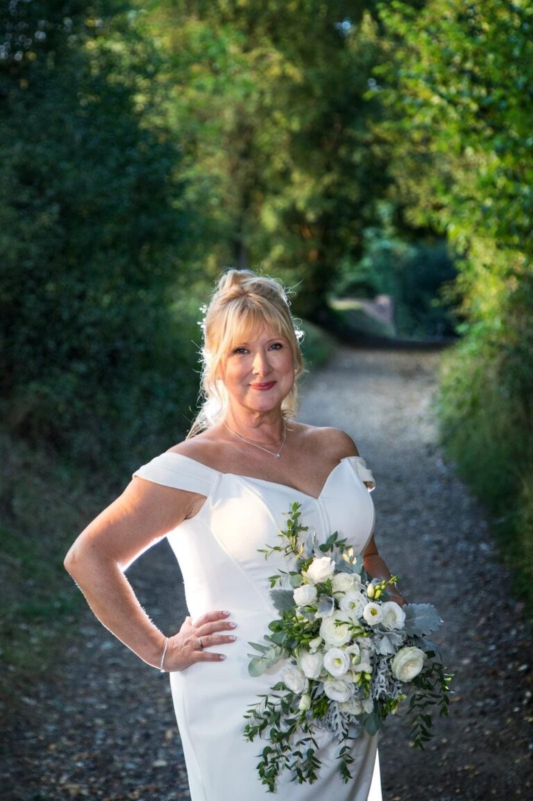 A bride's portrait, fitted ivory gown, a garden path behind her, Makeup By Mirna