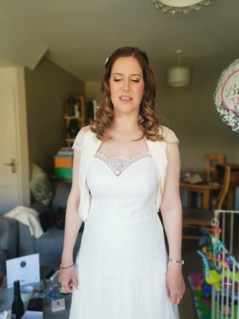 A bride's portrait, lace cap sleeves, a candid smile, Makeup By Mirna
