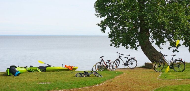 Kayaks and bicycles on the lagoon shore, Manowce Palace