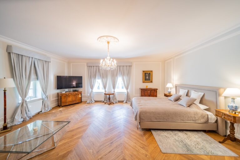 Suite bedroom with chandelier and herringbone parquet, Manowce Palace