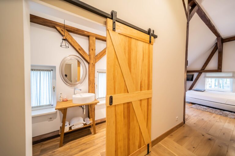 Annex room with timber frame and barn-door bathroom, Manowce Palace
