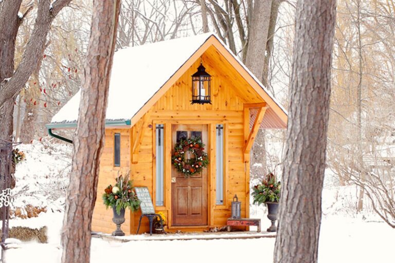 The Little Log Chapel dressed with a wreath and lanterns among snow-covered trees, Niagara, Maple Leaf Weddings