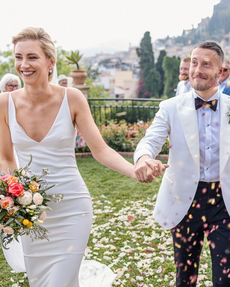 Bride and groom laughing as petals fall in a garden above Taormina, Marco Ficili