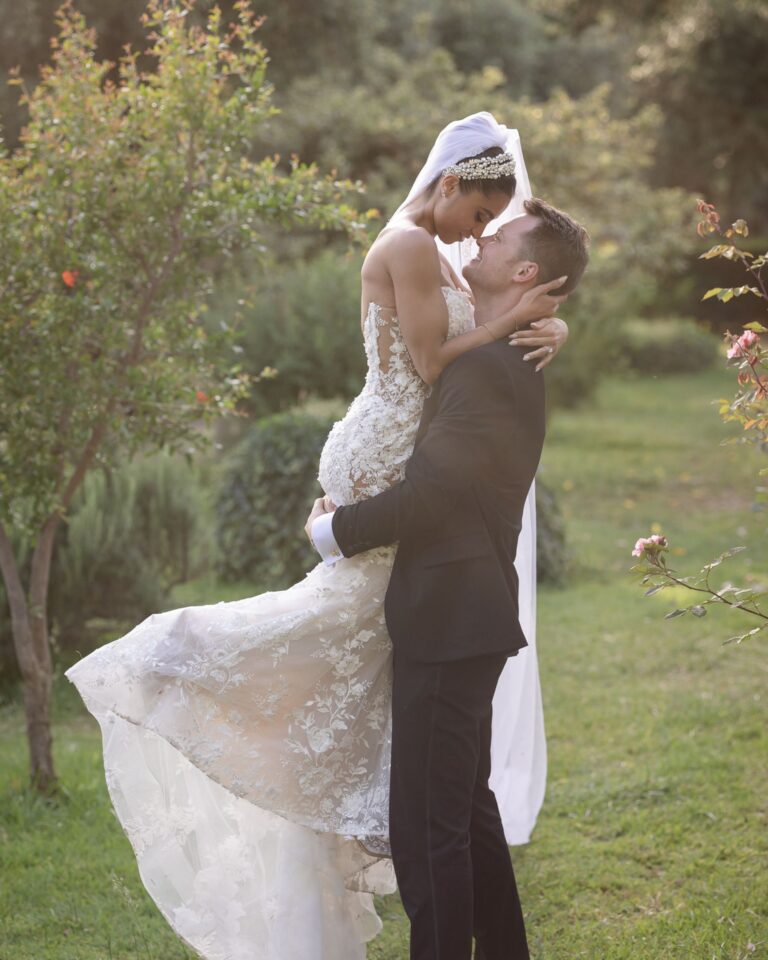 The groom lifting the bride in a garden at sunset, Marco Ficili