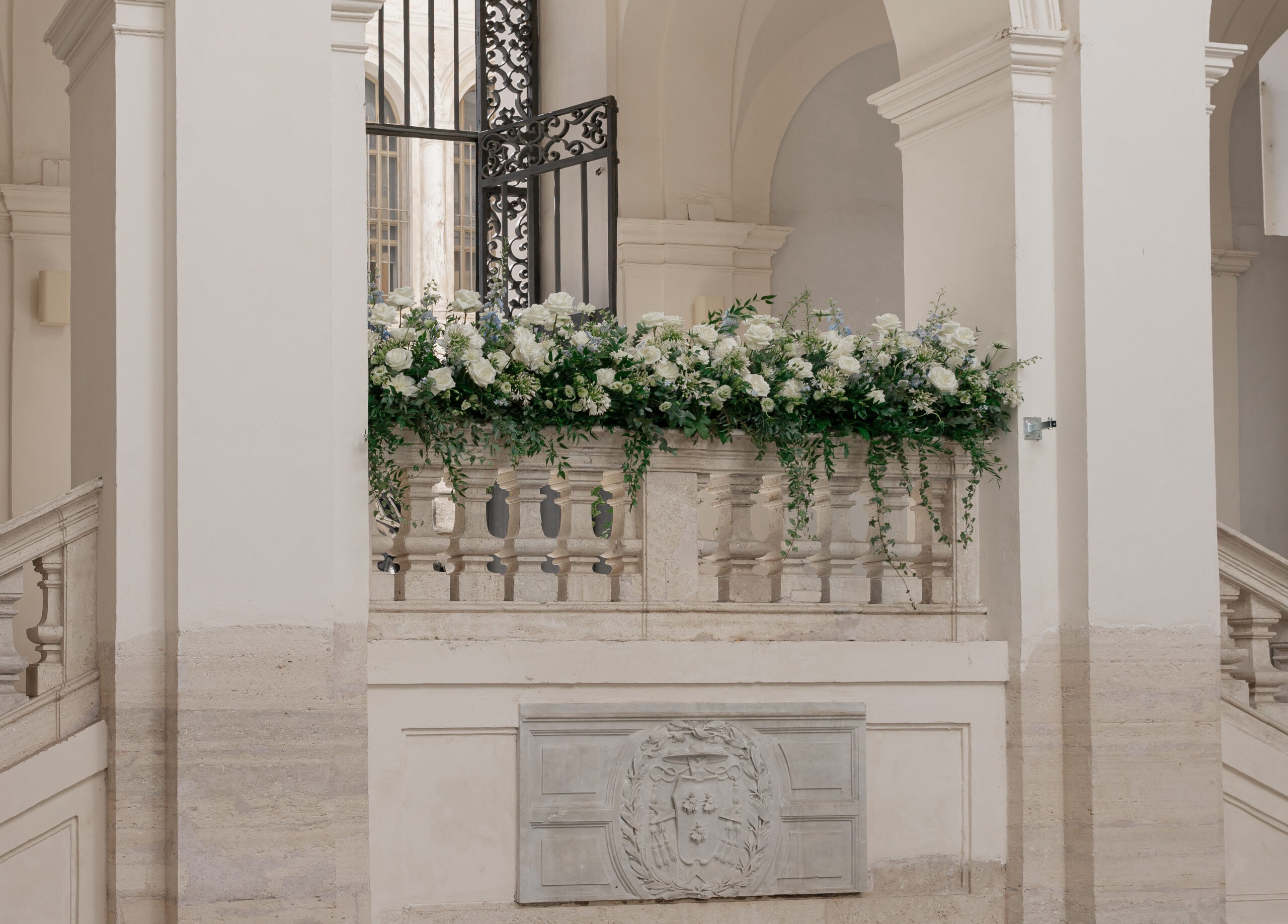 A floral garland dresses a wrought-iron balcony gate, Maria Luisa Rocchi Flowers