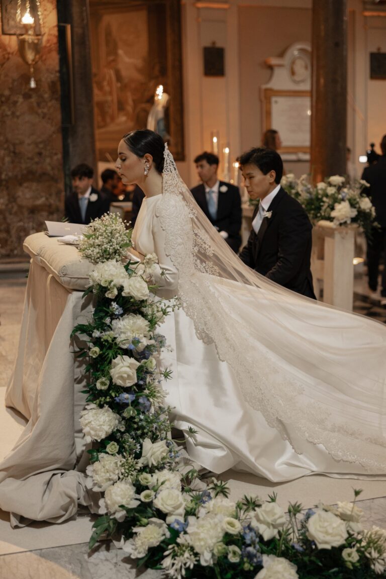 The bride signs the register beside a cascading floral runner, Maria Luisa Rocchi Flowers