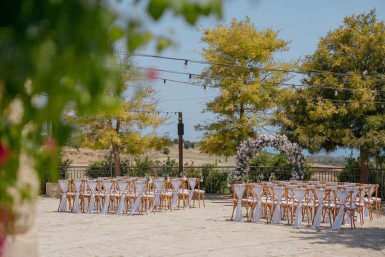 Ceremony chairs and floral arch among trees at Liopetro, Kouklia, Marry Me Cyprus