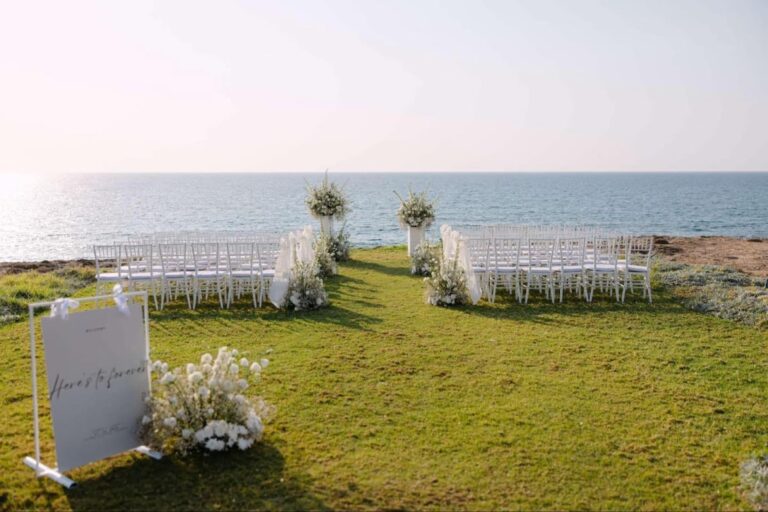 Clifftop ceremony lawn with chairs, floral installations and welcome sign at Alassos, Paphos, Marry Me Cyprus