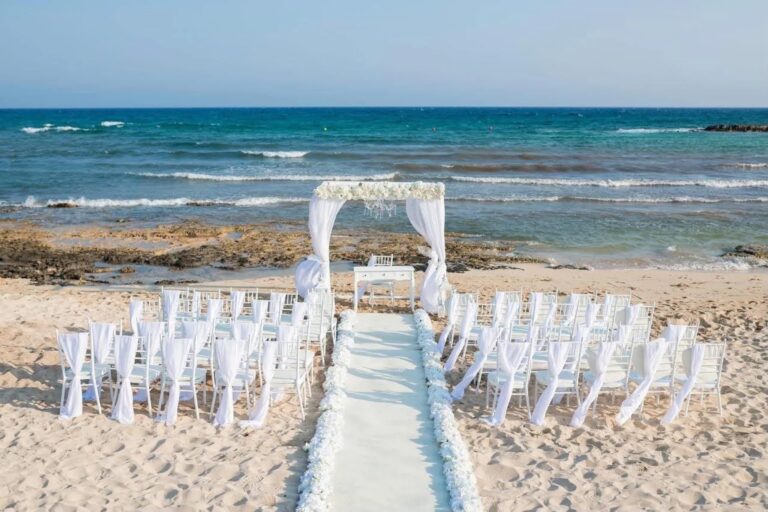 Beach ceremony set-up with canopy arch and white chairs at Ayia Thekla, Marry Me Cyprus