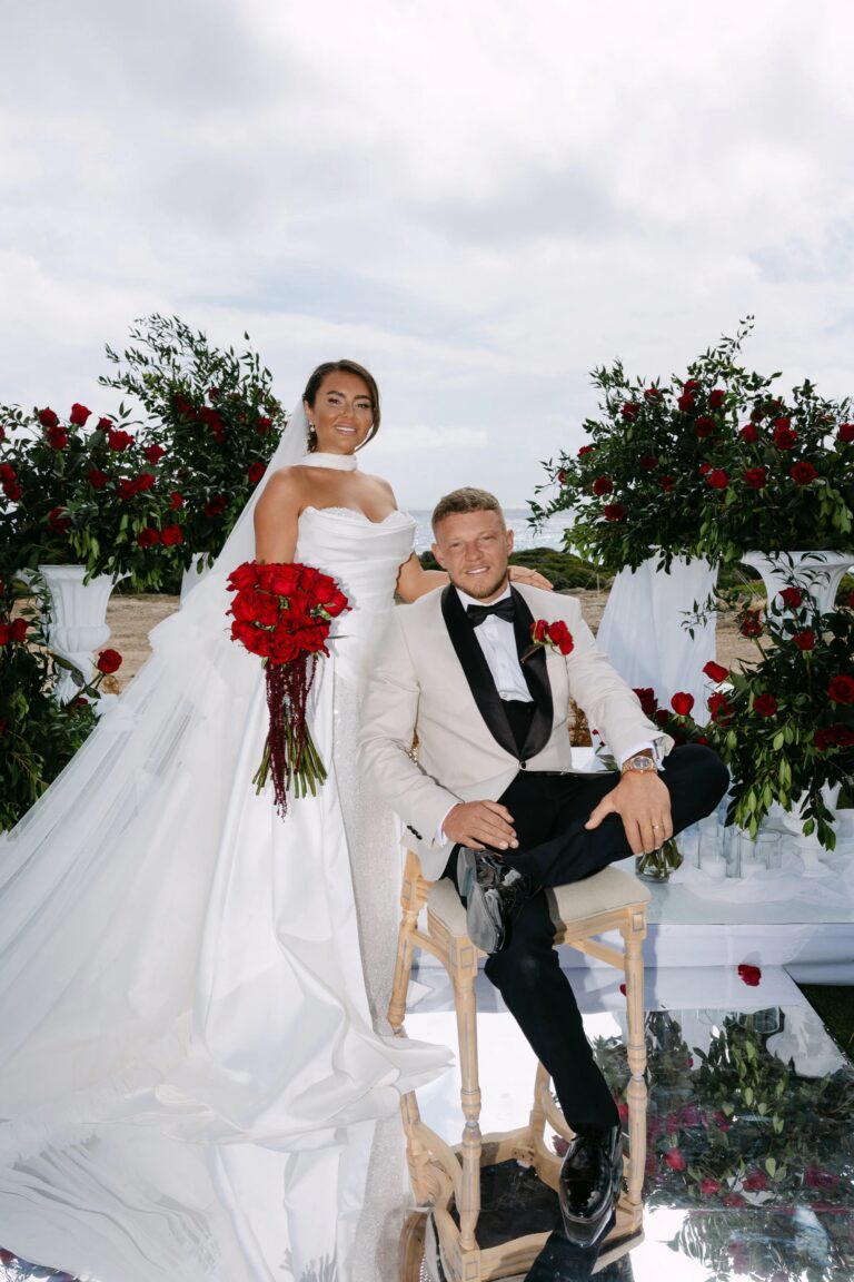 Couple seated among red roses at OZEA, Sea Caves, Paphos, Marry Me Cyprus