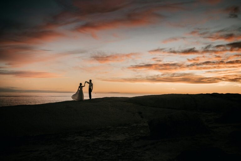 Couple silhouetted on a headland beneath a sunset sky, Paphos, Marry Me Cyprus