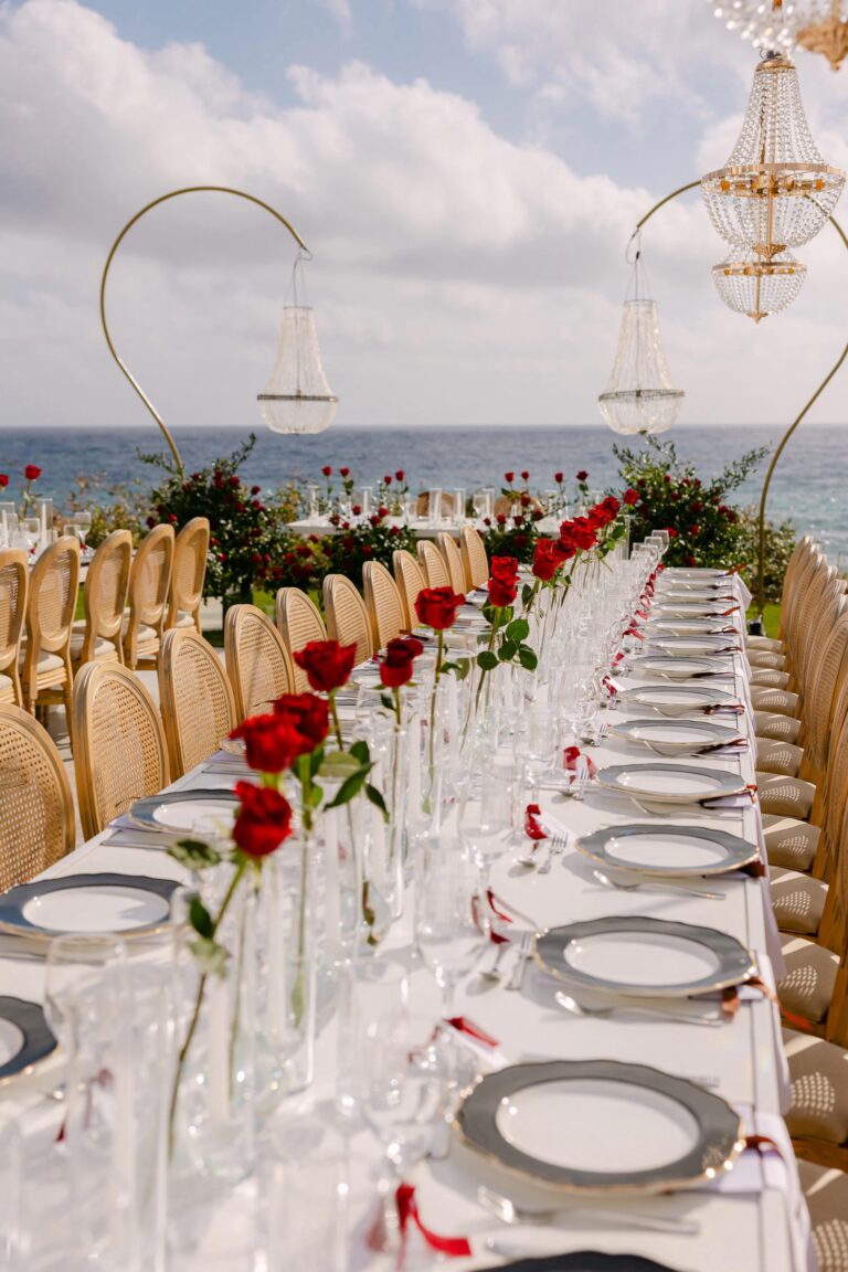 Long guest table with red roses and gold-framed chairs at OZEA, Sea Caves, Paphos, Marry Me Cyprus