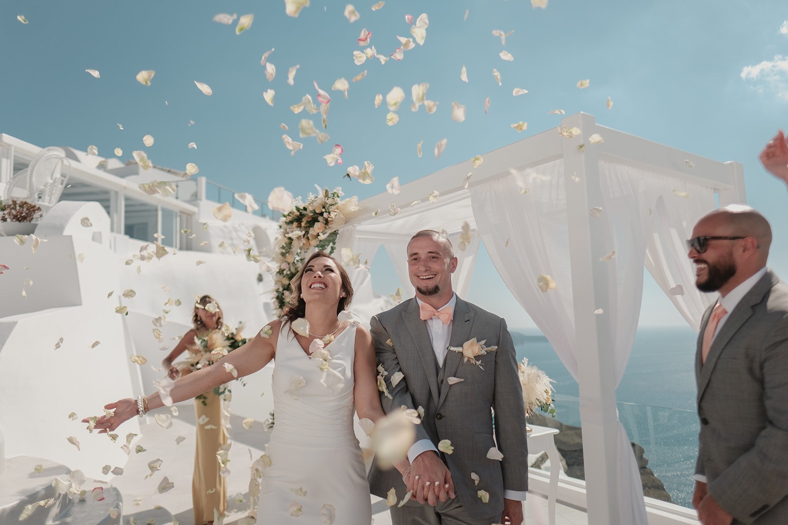 Couple with petals in the air after a ceremony beneath a white canopy, Marryme in Greece