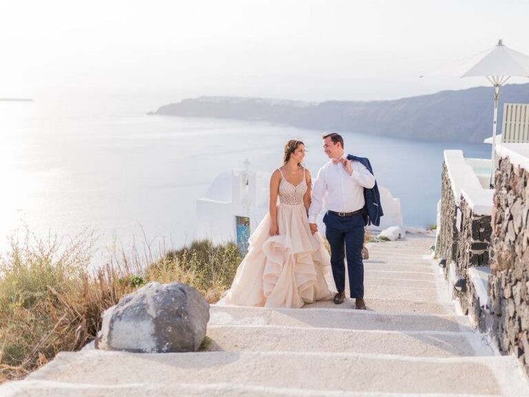 Couple walking down white steps above the sea, Marryme in Greece