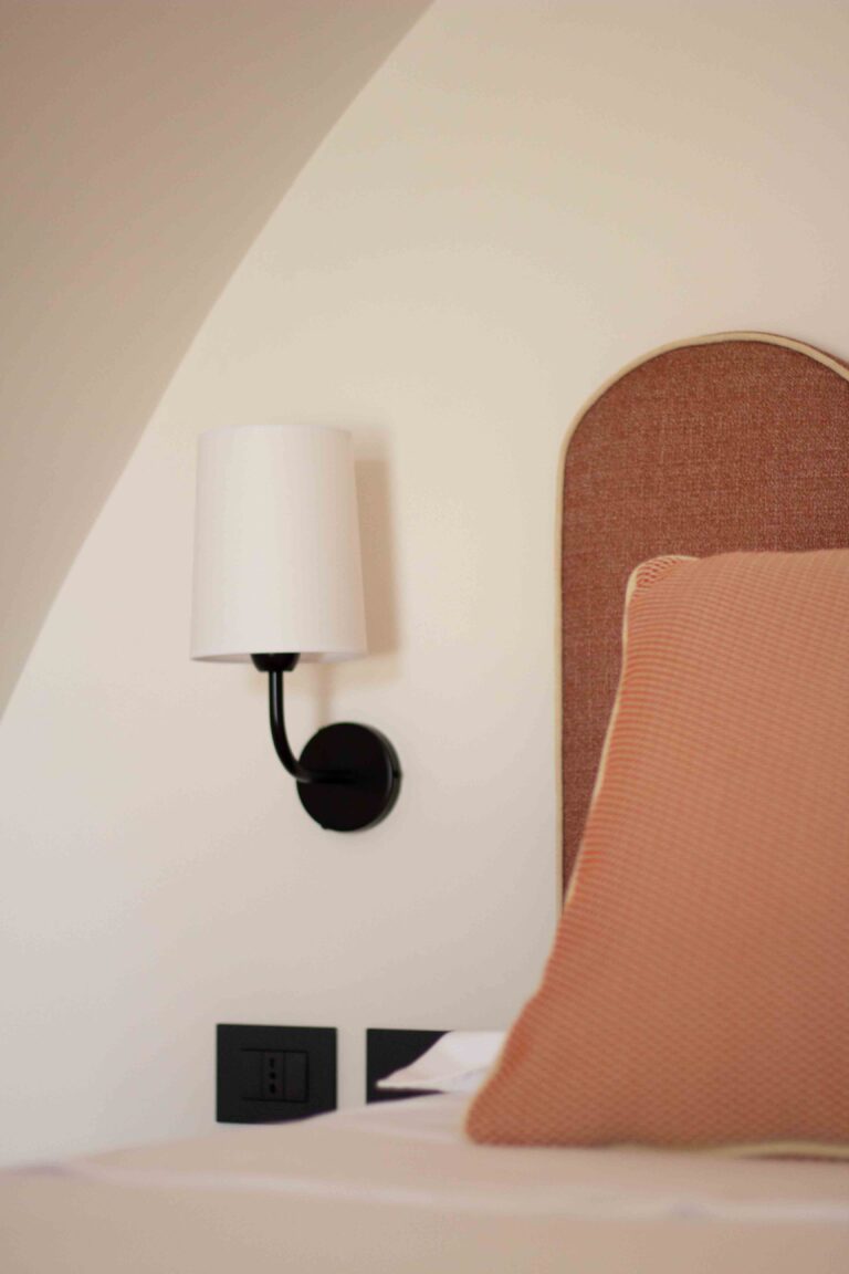 A terracotta headboard and cushion beside a wall lamp, Superior Attic Double Room, Masseria Don Luigi
