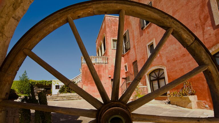 The red-walled masseria seen through a cartwheel, Masseria Spina Resort