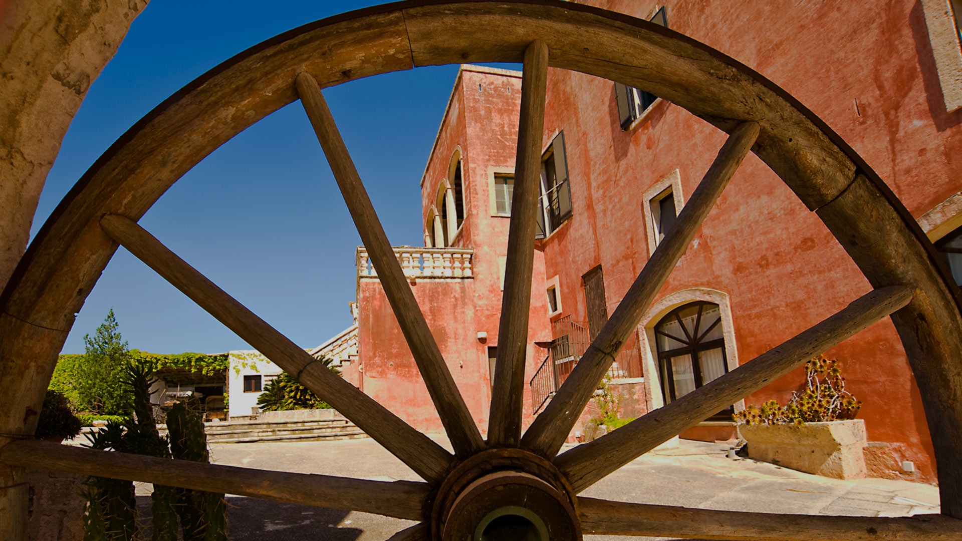 The red-walled masseria seen through a cartwheel, Masseria Spina Resort
