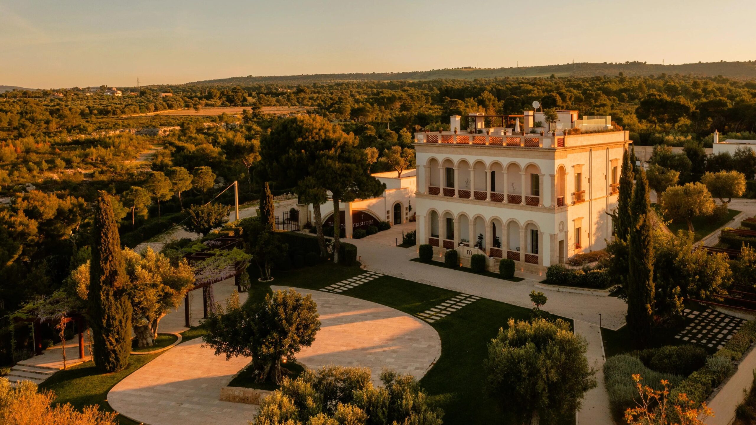 Aerial view of the estate and its gardens at golden hour, Mastropà