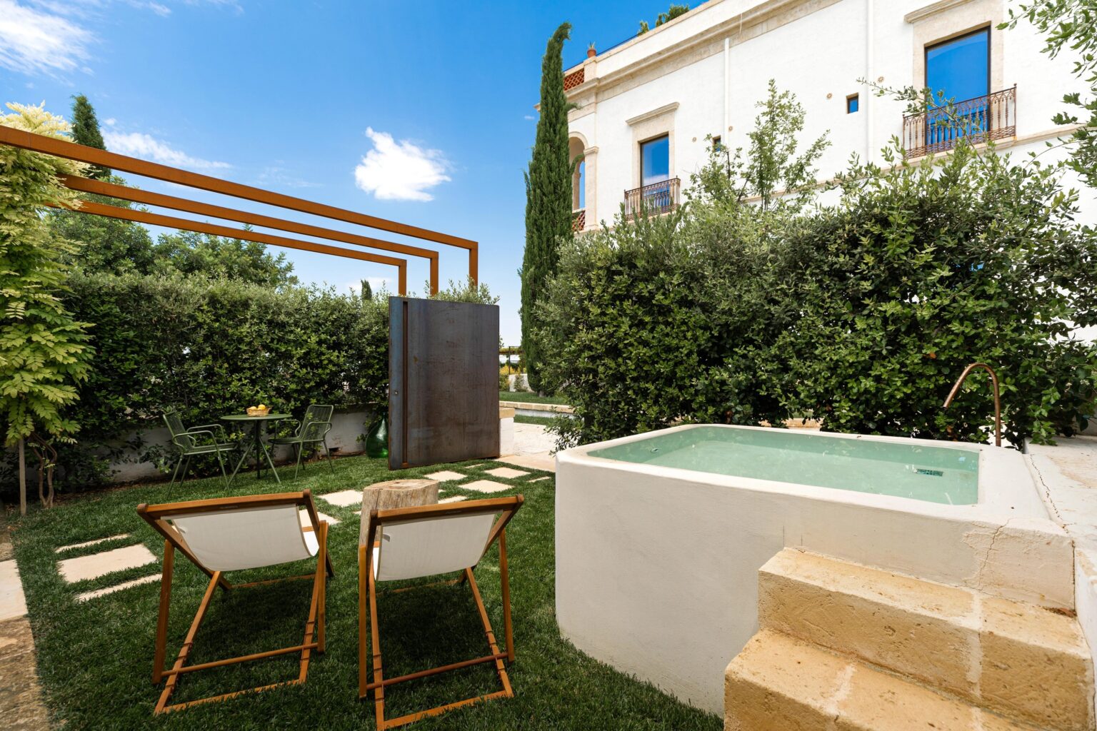 A private garden with a plunge tub at one of the Ancient Stables rooms
