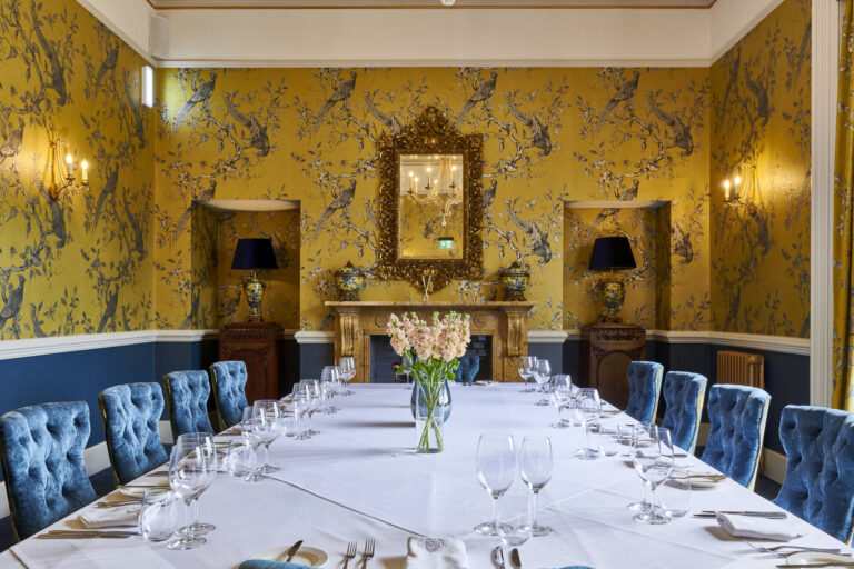 The Sapphire Room set for a private dinner at one long table, with yellow chinoiserie wallpaper, Matfen Hall
