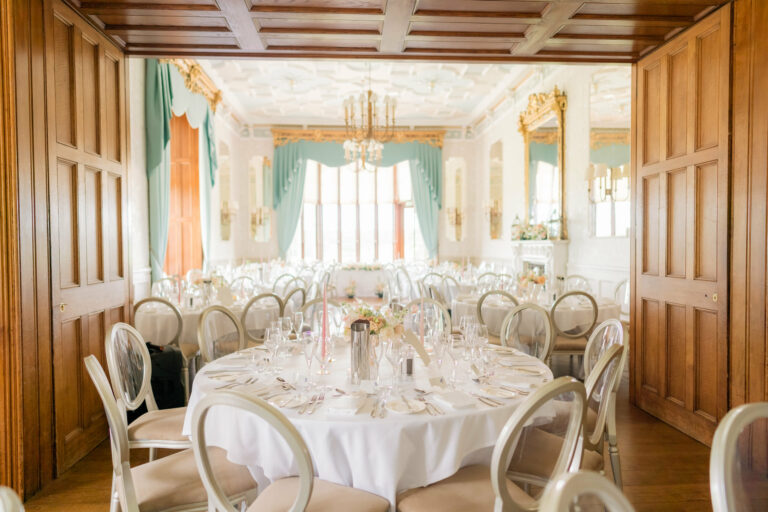View through panelled double doors into the Drawing Room set with round tables for a wedding breakfast, Matfen Hall