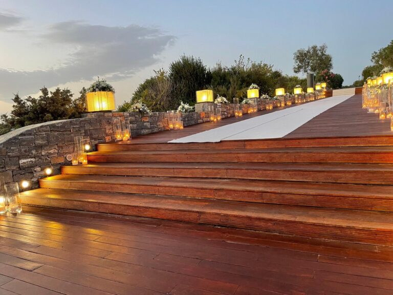 Wooden steps lit by lanterns, with a white aisle runner, Mathioudakis Exclusive Events