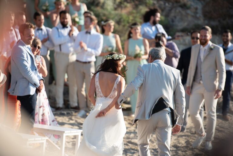 Couple walking to a ceremony on the beach, Mathioudakis Exclusive Events