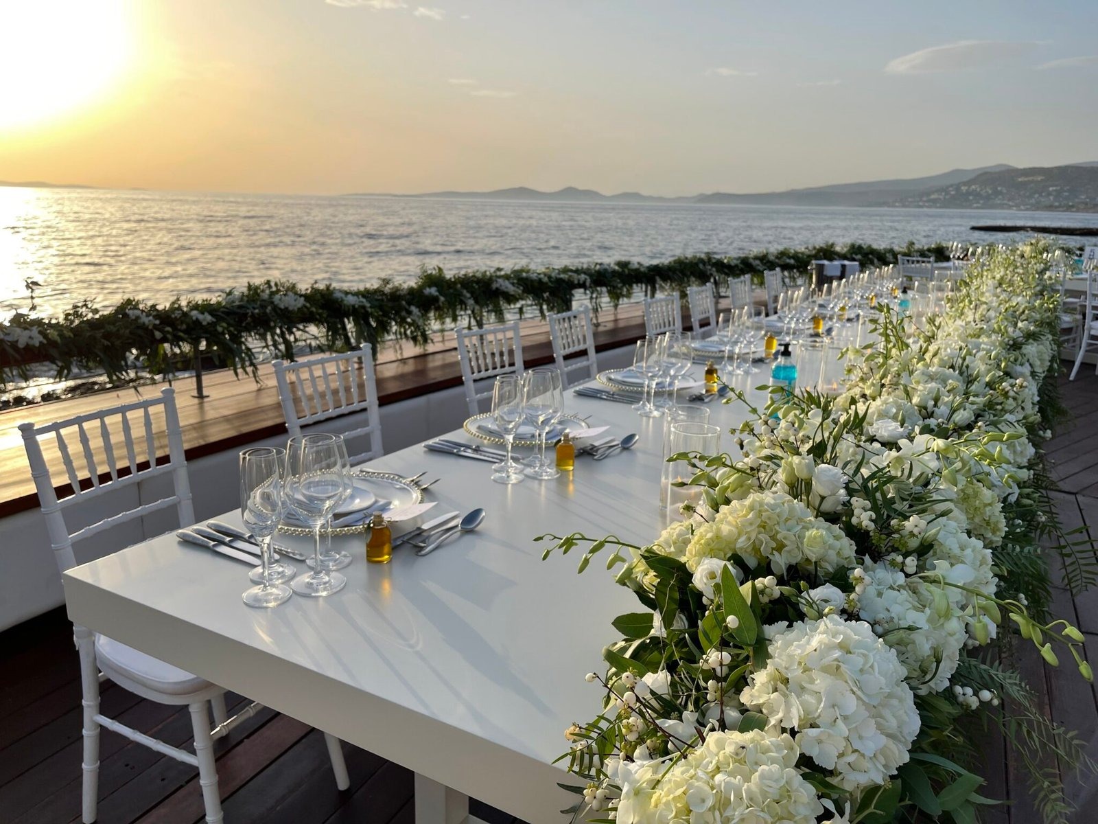 Long table with a white floral garland running its length, Mathioudakis Exclusive Events