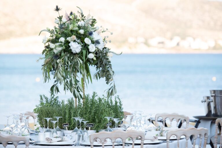 Tall green and white centrepiece on a beach-side table, Mathioudakis Exclusive Events