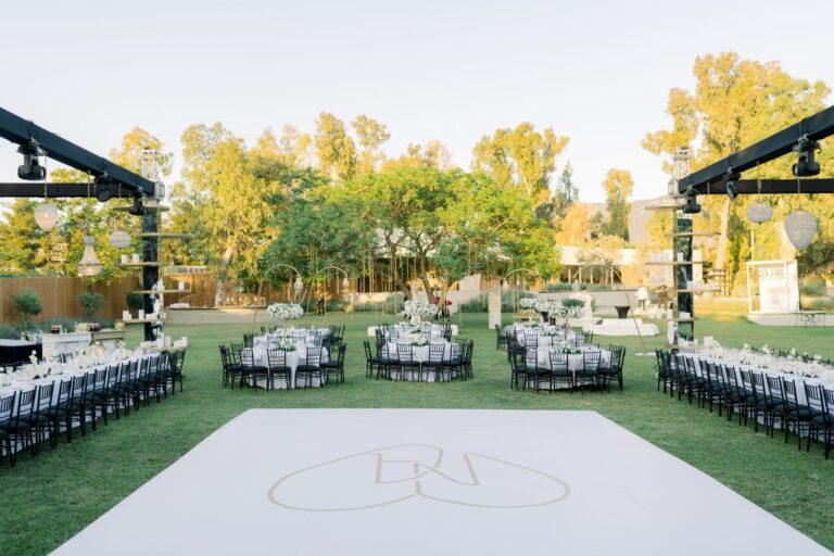 Garden lawn with a monogrammed white dance floor and long tables, Mathioudakis Exclusive Events