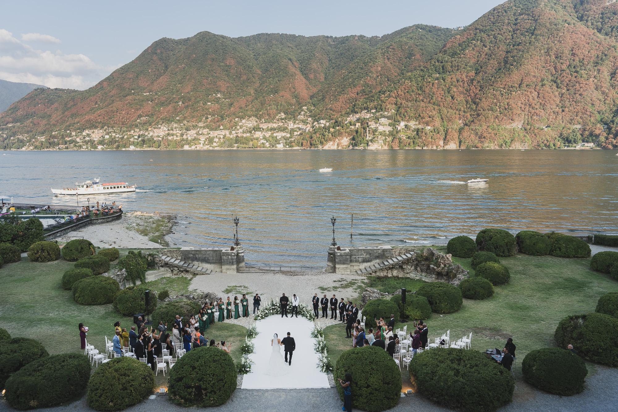 From above: a garden ceremony on the lawn at Villa Erba, Cernobbio, with Lake Como and the far shore behind, Matteo Cuzzola Photography