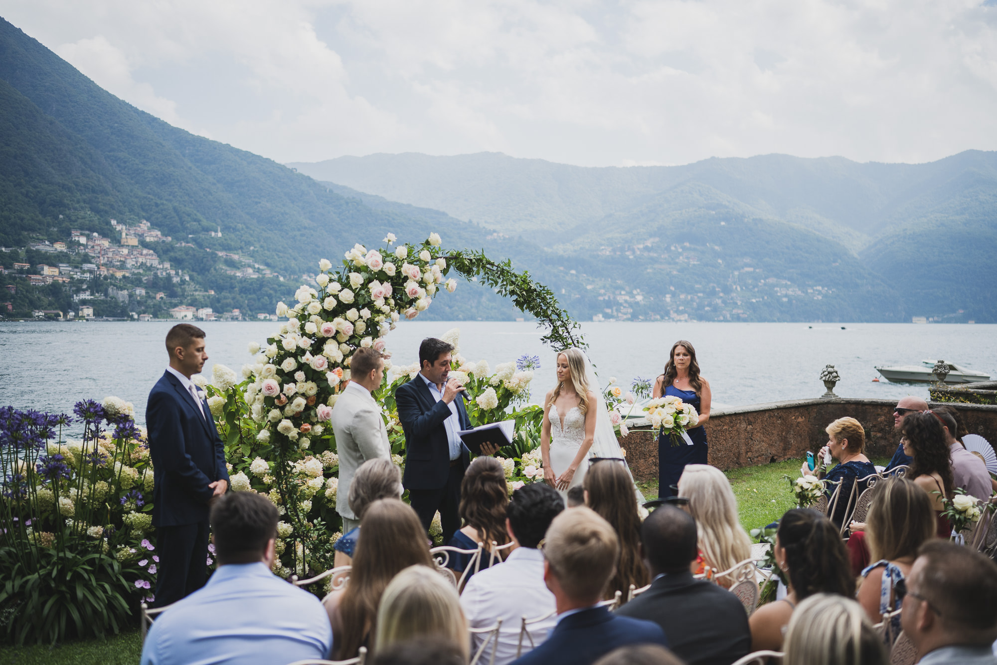 A lakeside ceremony under a flower arch at Villa Regina Teodolinda, Laglio, on Lake Como, Matteo Cuzzola Photography