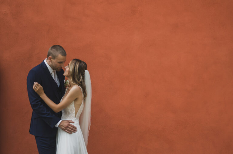 A couple against a terracotta wall, from an intimate wedding at Villa Cipressi, Varenna, Matteo Cuzzola Photography