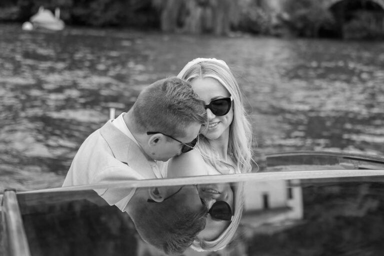 A couple on a boat, reflected in the polished deck, from his Villa Regina Teodolinda wedding page; black and white, Matteo Cuzzola Photography