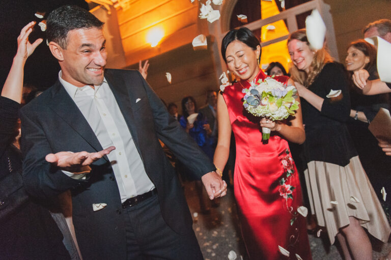 A bride in red and her groom dancing through a shower of petals, from his Villa d'Este page, Matteo Cuzzola Photography