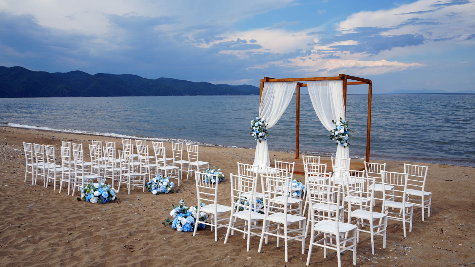 Beach ceremony aisle and arch beside the sea at dusk, Mazal Weddings