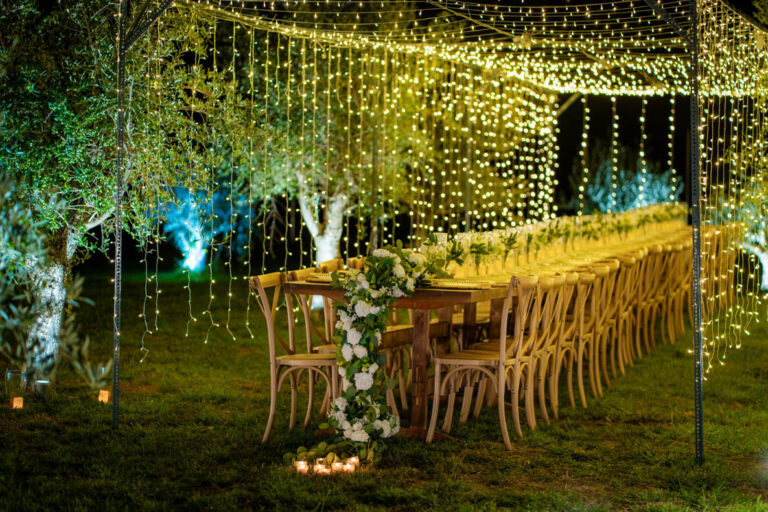 Reception table set among lit trees, Mazal Weddings
