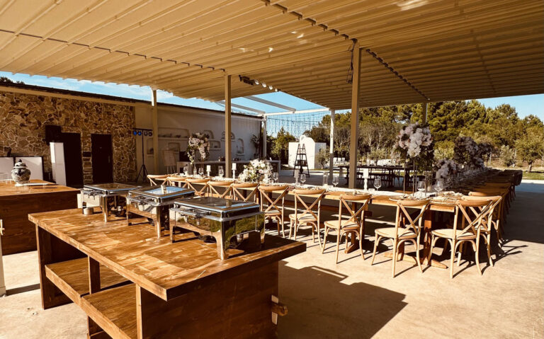 Covered terrace with buffet stations and a long reception table, Mazal Weddings