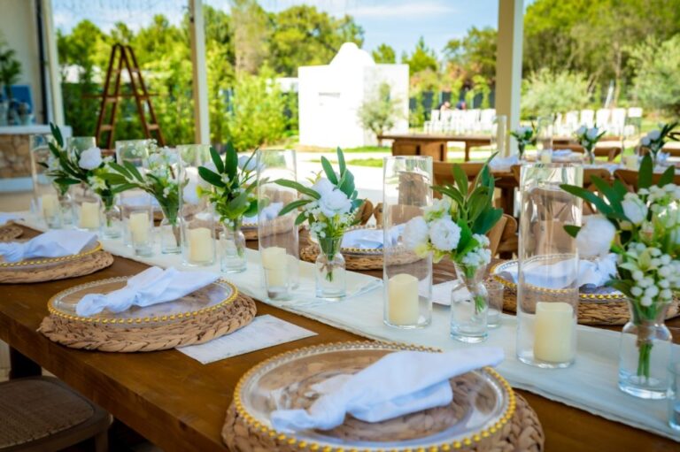 A table set with woven placemats, candles and white flowers, Mazal Weddings
