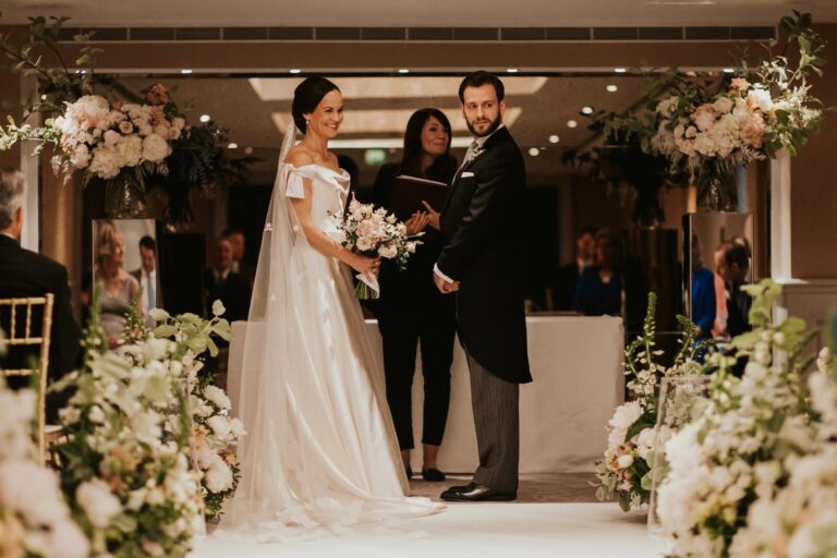 An indoor ceremony framed by hanging floral arches, an intimate London city wedding, McQueens Flowers