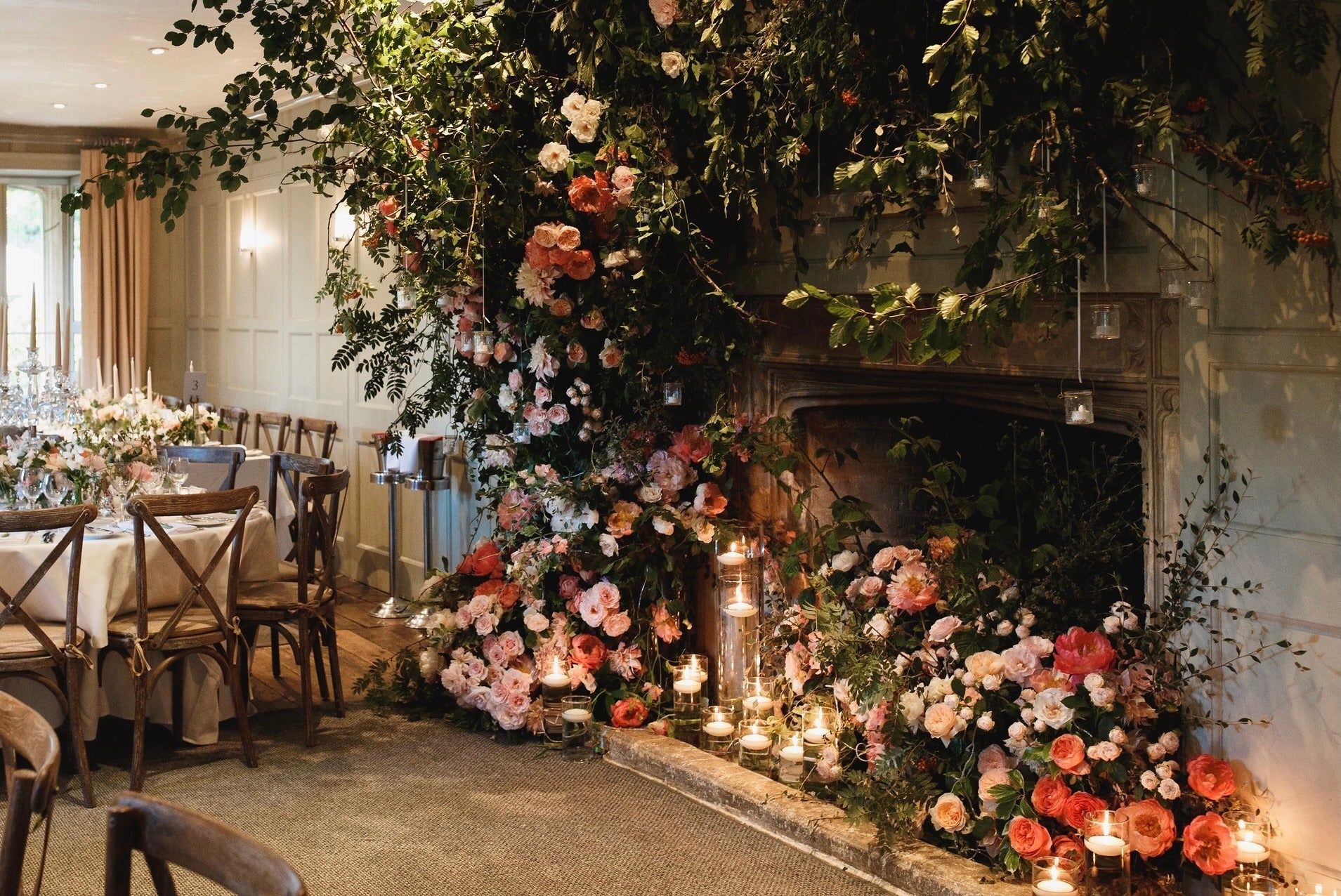 Garden rose and dahlia climb from the hearth to the ceiling, Barnsley House, McQueens Flowers