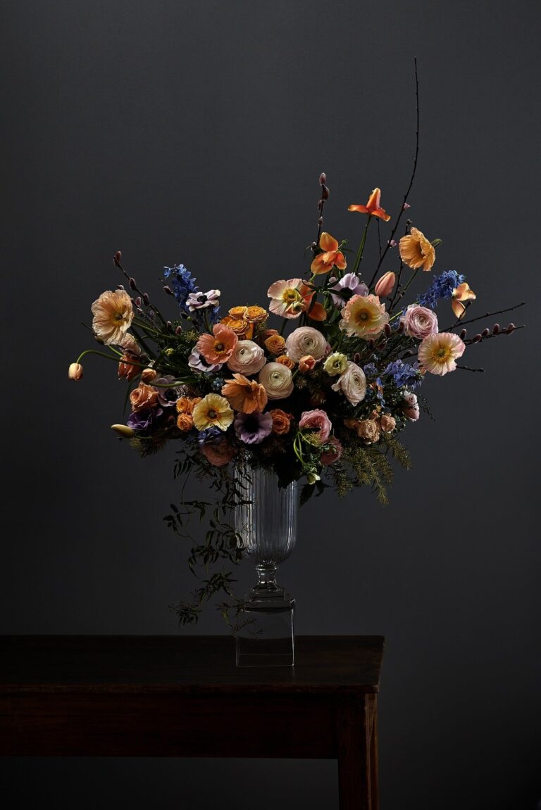 A tall arrangement of ivory rose, trailing to the table, McQueens Flowers