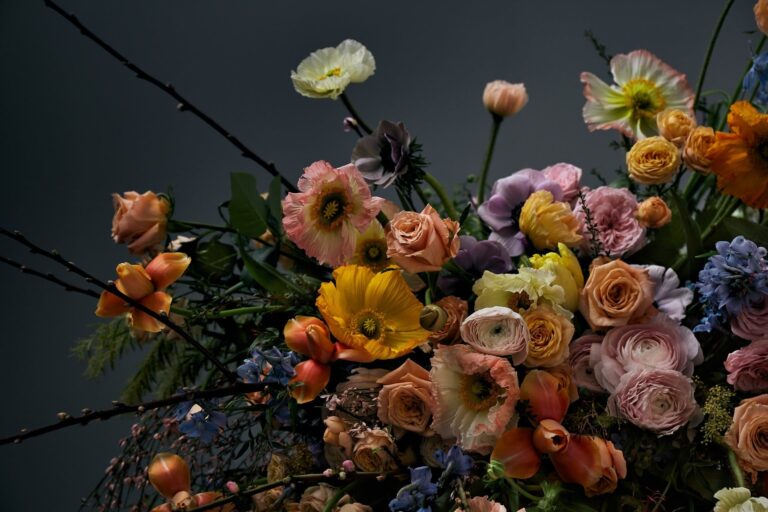 A seasonal arrangement of poppy, ranunculus and flowering branch, McQueens Flowers