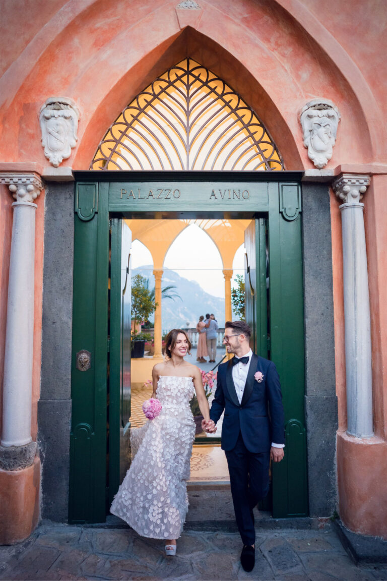 The bride and groom stepping out of the Gothic doorway of Palazzo Avino in Ravello, its name carved above the door, Med inStyle